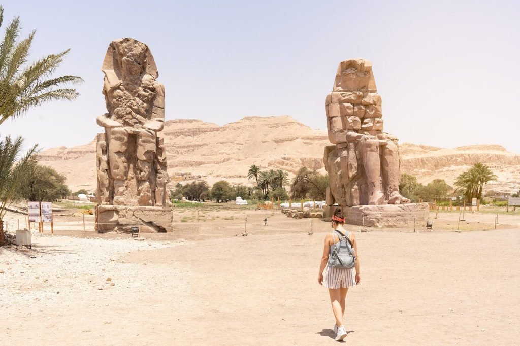A traveler walking towards the Colossi of Memnon