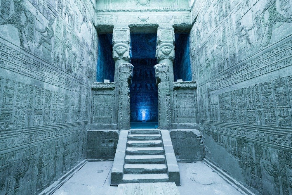 An inner hall of the Dendera temple with carved walls and steps to a sanctuary
