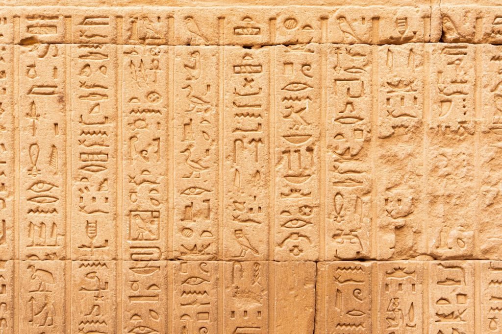 Rows of hieroglyphs carved in relief on a sandstone temple wall