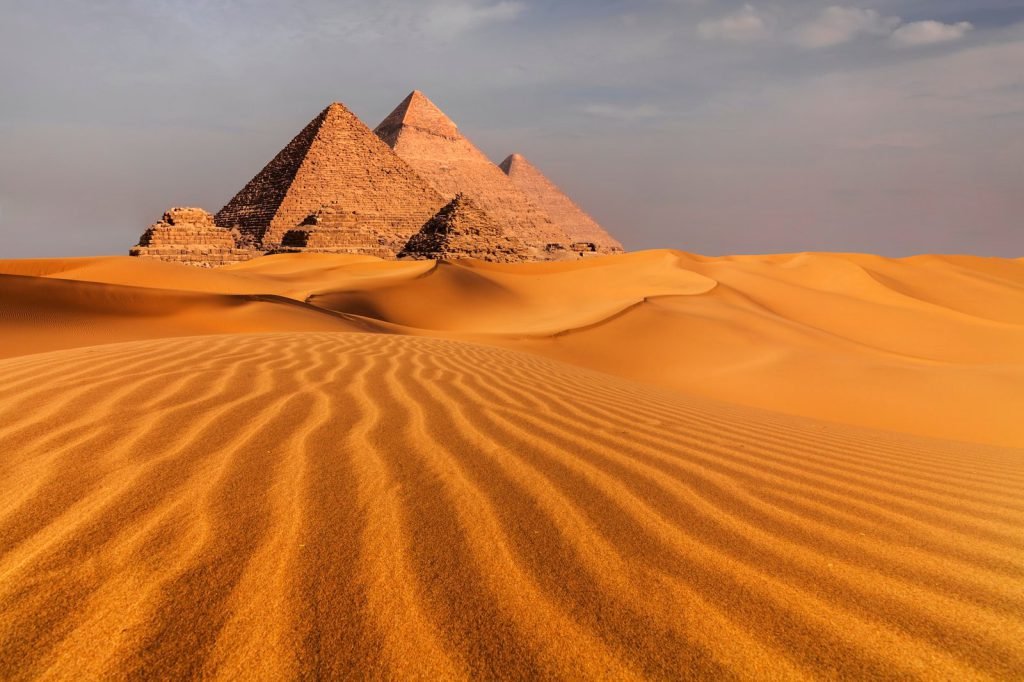 Cairo and Giza tours – the pyramids of Giza above the desert sand at sunset