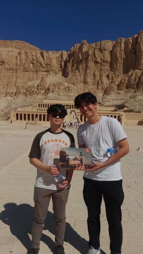Two travelers in front of the Temple of Hatshepsut