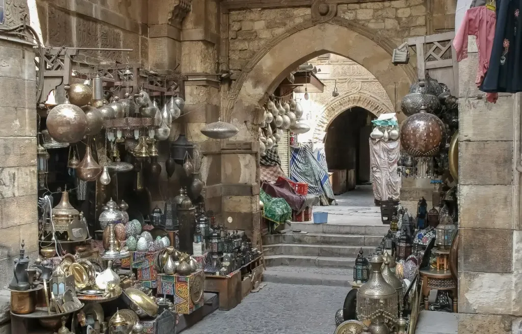 Brass lanterns and metalwork displayed under a stone archway in Khan el-Khalili