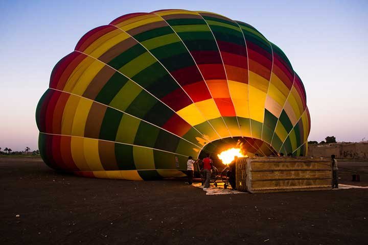 A burner firing into a striped balloon before take-off