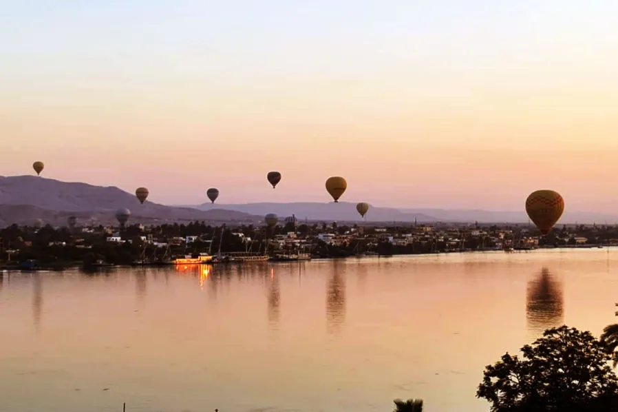 Hot-air balloons rising over the Nile at Luxor at sunrise