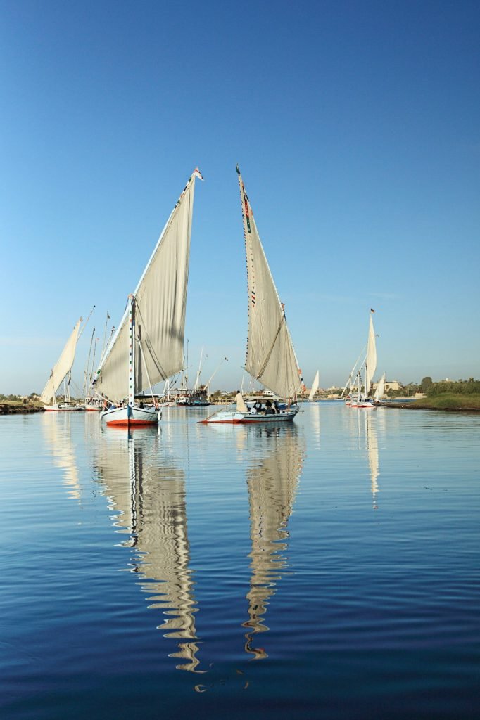 White felucca sails reflected in the calm Nile