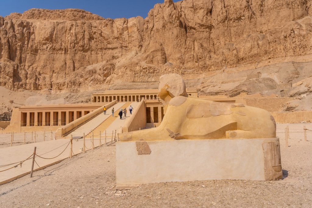 A sphinx before the terraces of Hatshepsut's temple under the Deir el-Bahari cliffs