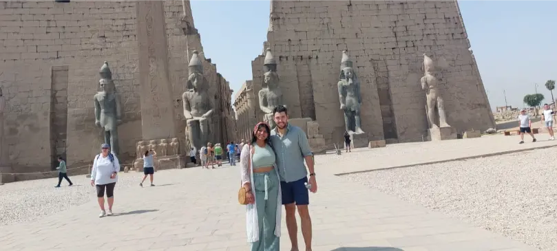 Two travelers in front of the entrance pylon and statues of Luxor Temple
