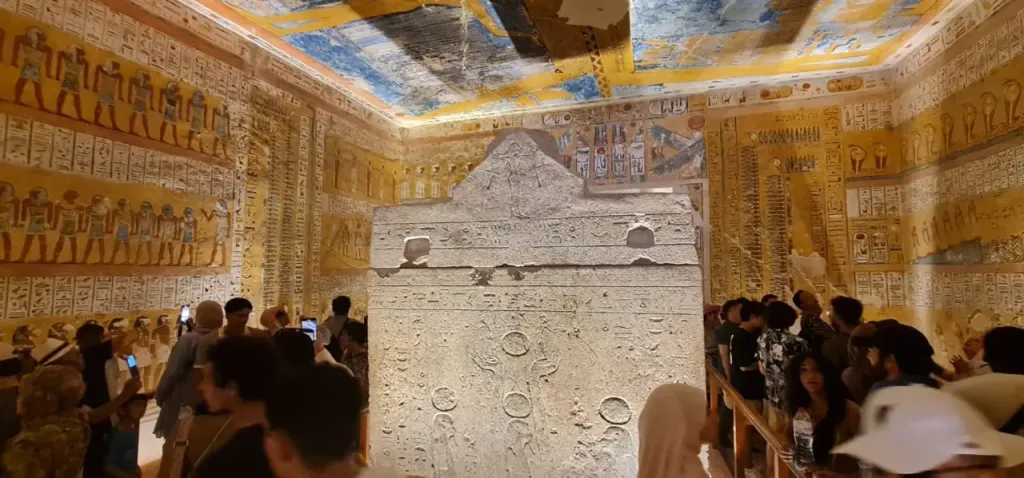 A carved stone sarcophagus in a painted royal tomb in the Valley of the Kings