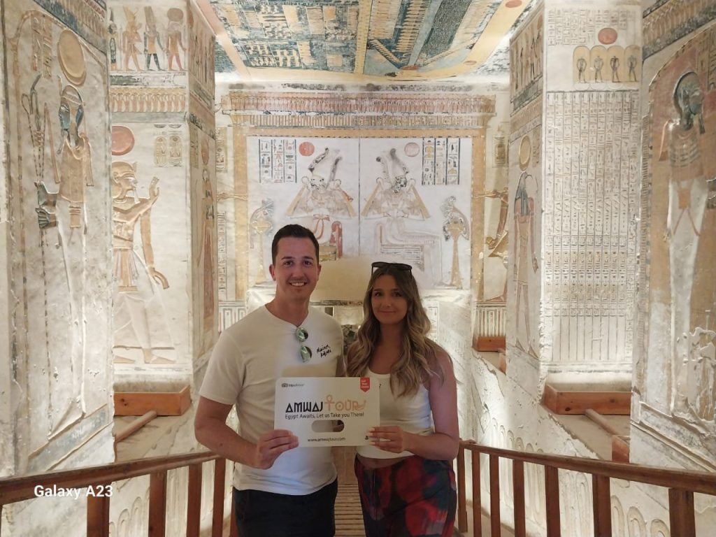 Travelers inside a painted royal tomb in the Valley of the Kings