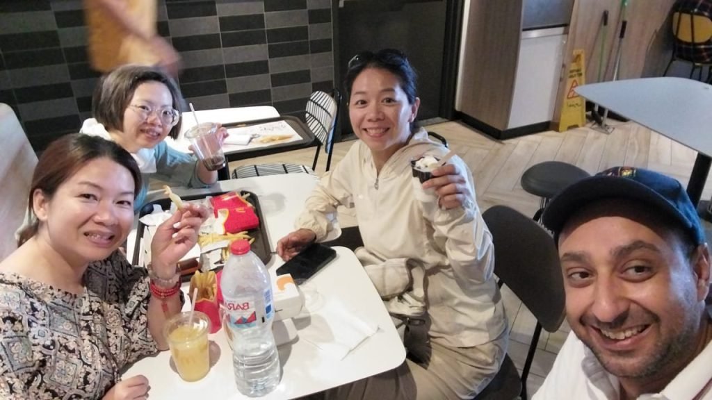 An Amwaj Tour guide taking a selfie with smiling travelers during a coffee break