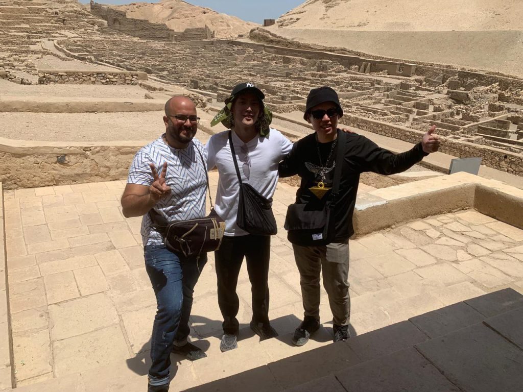 An Amwaj Tour guide and two travelers giving a thumbs up at the Temple of Hatshepsut