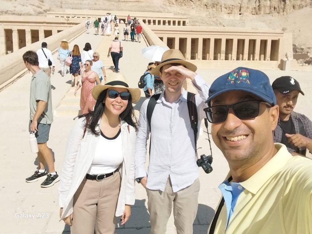 An Amwaj Tour guide taking a selfie with two travelers at the Temple of Hatshepsut
