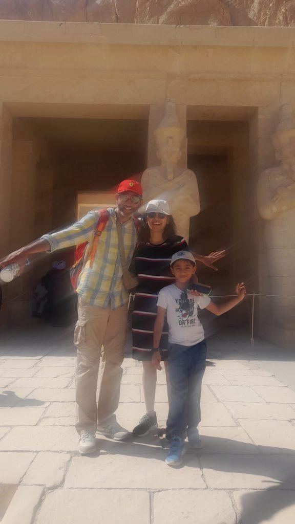 A family posing beside the Osiris statues of the Temple of Hatshepsut