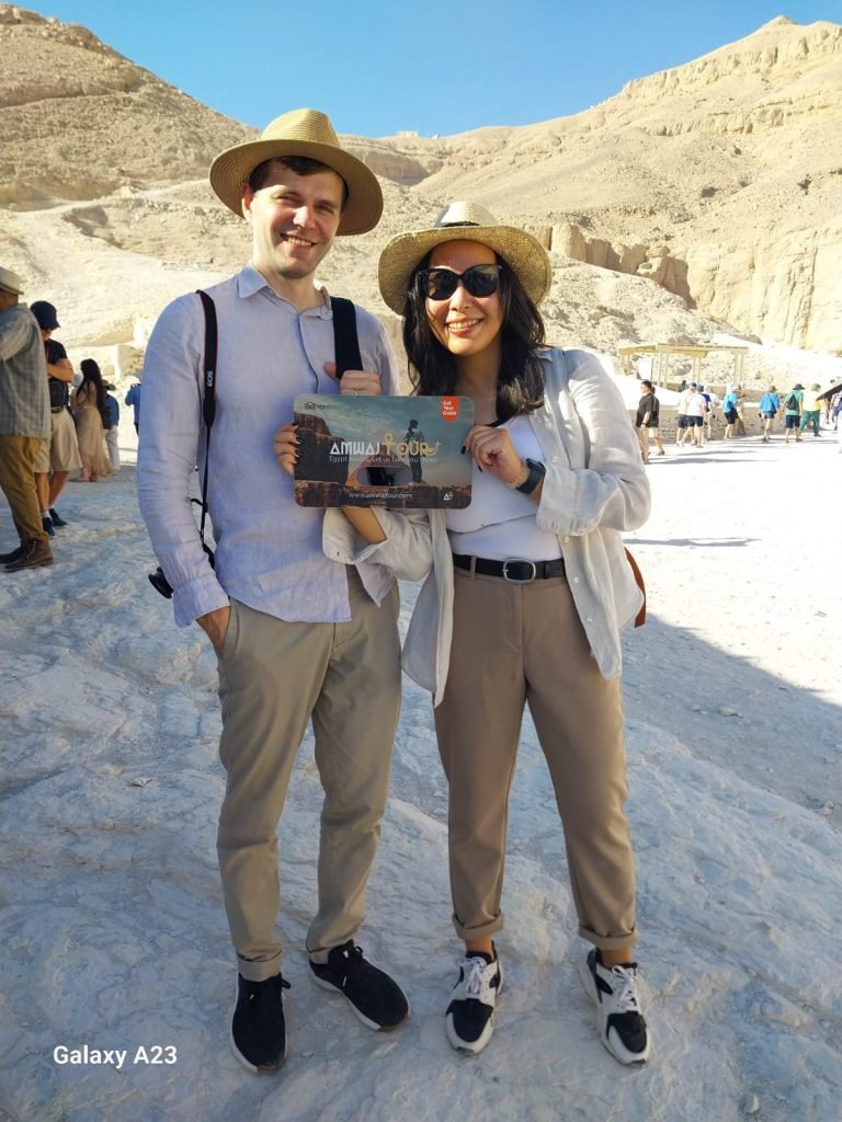 A couple with an Amwaj Tour photo card in the Valley of the Kings