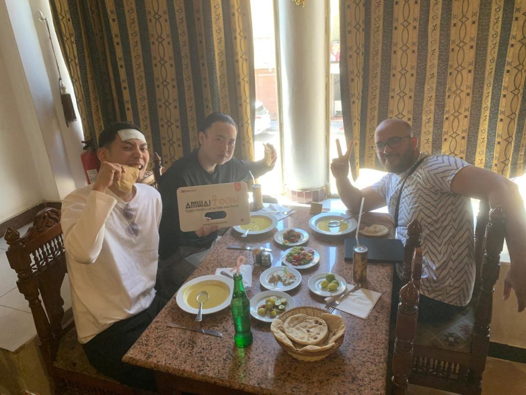 An Amwaj Tour guide sharing a traditional Egyptian lunch with two travelers